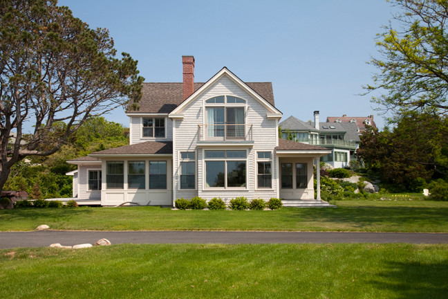 На фото: двухэтажный, деревянный, серый частный загородный дом среднего размера в морском стиле с вальмовой крышей и крышей из гибкой черепицы с