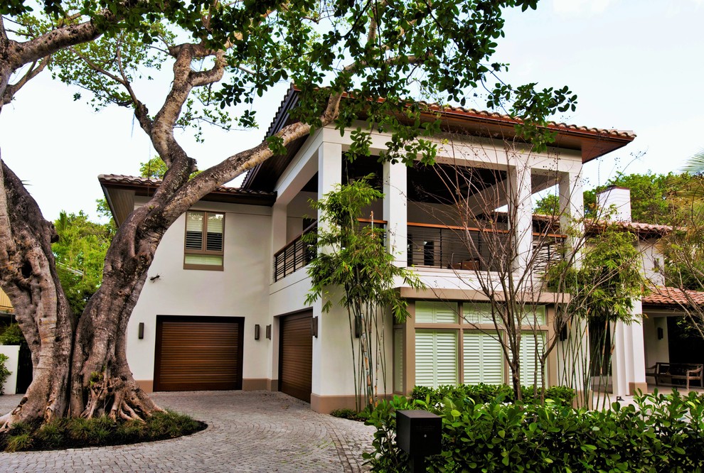 Design ideas for a large and white mediterranean two floor house exterior in Miami.