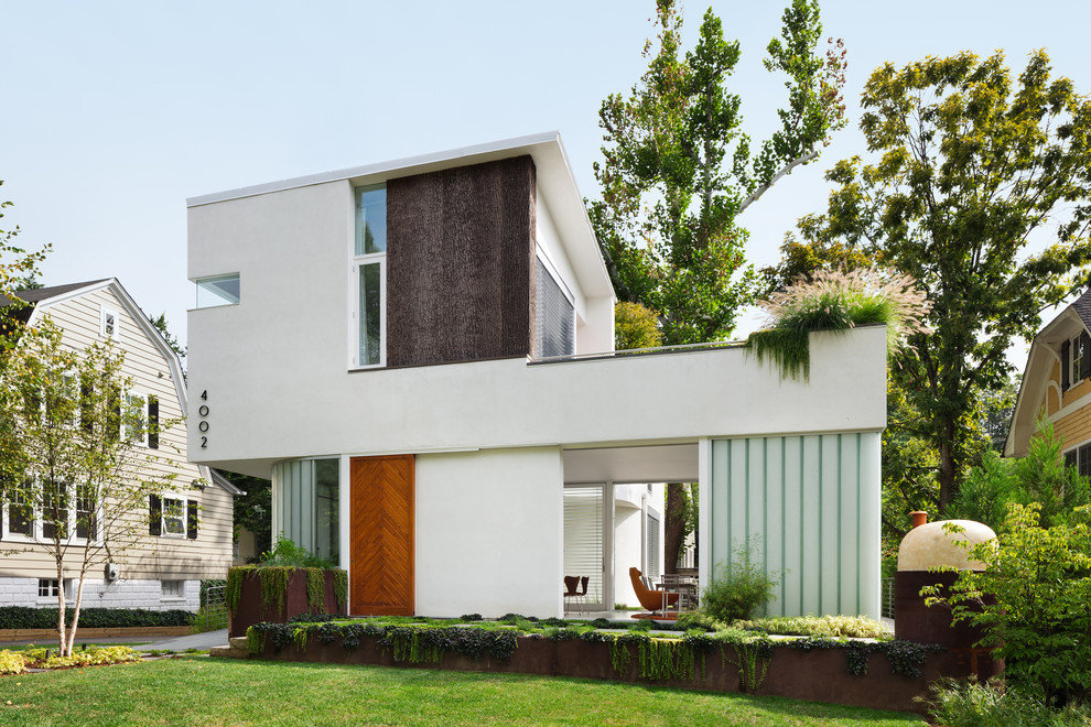 На фото: большой, трехэтажный, белый дом в современном стиле с облицовкой из цементной штукатурки и плоской крышей с