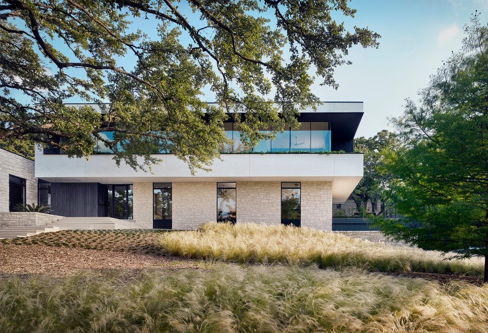 Zweistöckiges Modernes Einfamilienhaus mit Mix-Fassade, weißer Fassadenfarbe und Flachdach in Austin
