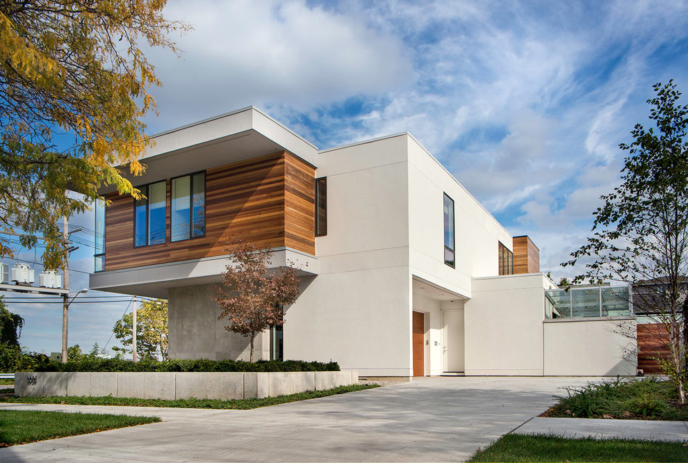 Imagen de fachada de casa blanca contemporánea grande de tres plantas con revestimientos combinados y tejado plano