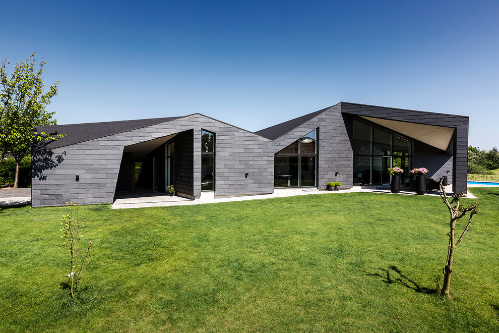 Стильный дизайн: черный дом среднего размера в современном стиле с разными уровнями, облицовкой из ЦСП и односкатной крышей - последний тренд