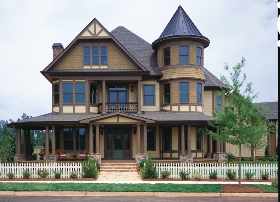 Modelo de fachada marrón tradicional renovada grande de tres plantas con revestimientos combinados y tejado a dos aguas