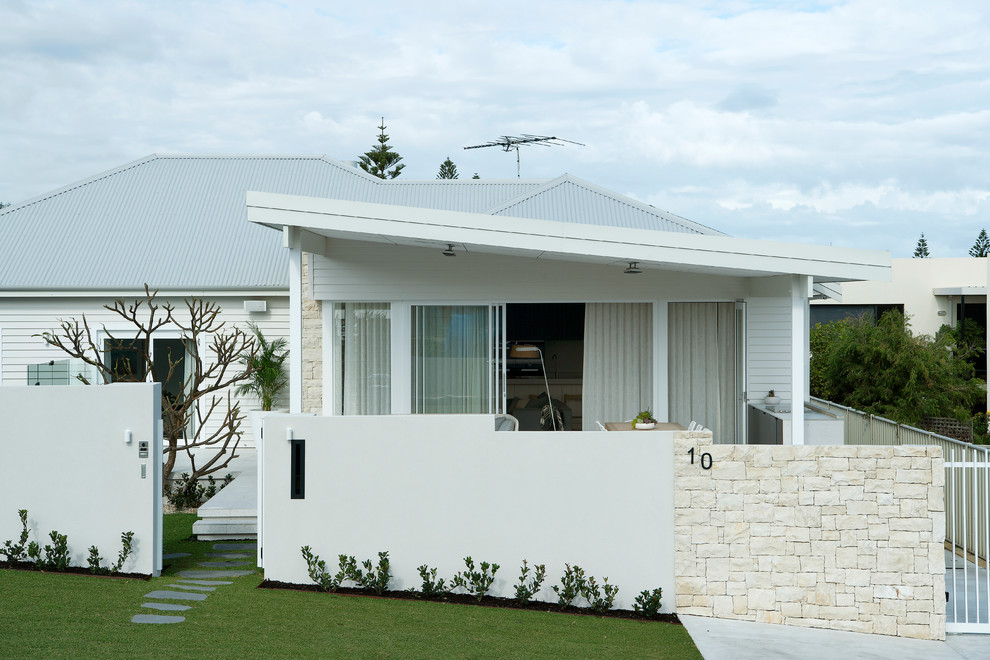 Foto de fachada de casa blanca de tamaño medio de una planta con revestimientos combinados, tejado a cuatro aguas y tejado de metal