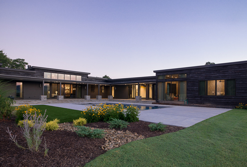 На фото: огромный, одноэтажный, деревянный, коричневый частный загородный дом в стиле модернизм с