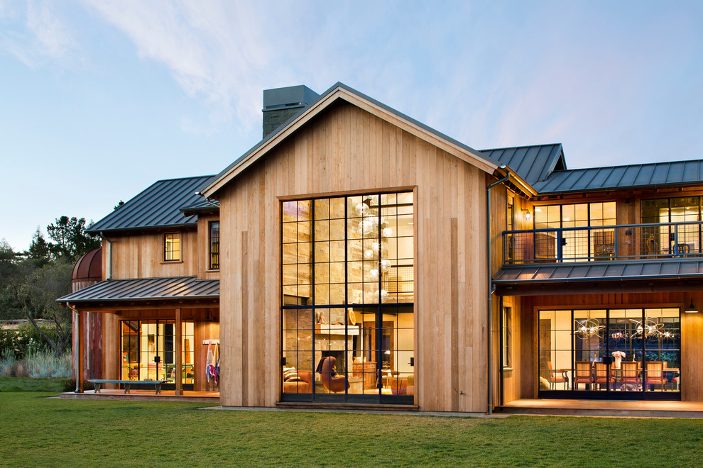 Idée de décoration pour une façade de maison champêtre en bois à un étage avec un toit à deux pans.