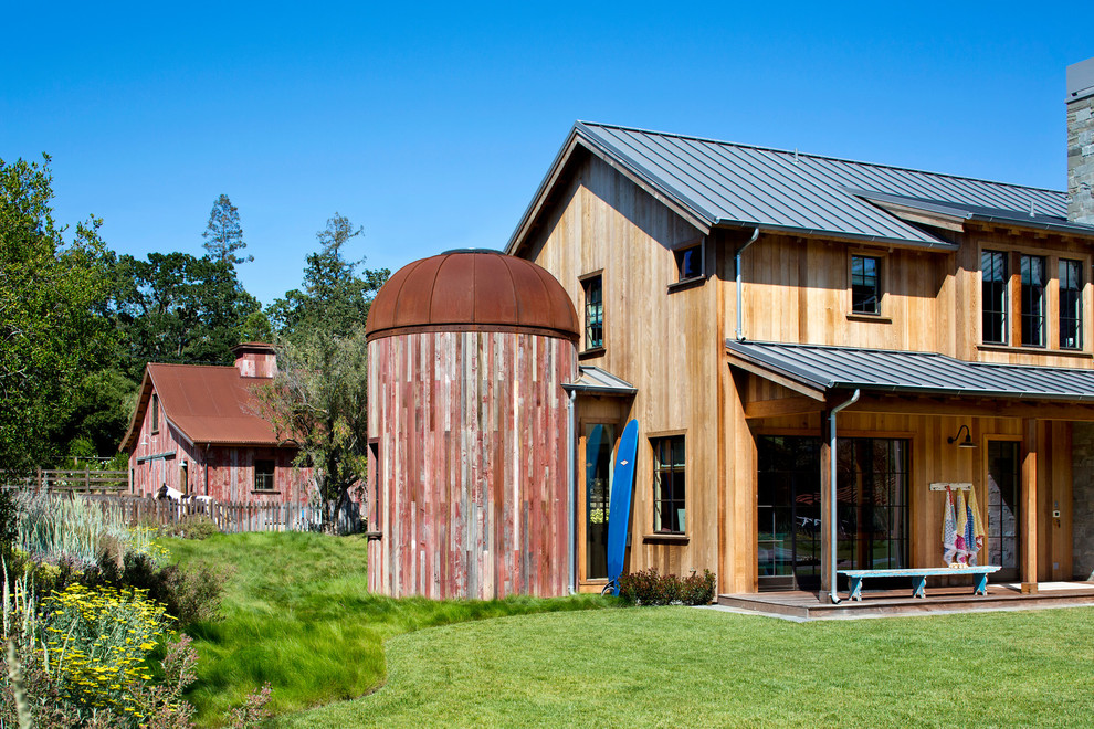 Idée de décoration pour une façade de grange rénovée champêtre en bois à un étage avec un toit à deux pans.