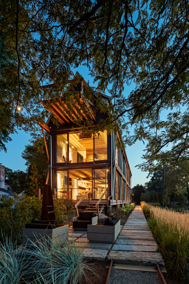 Стильный дизайн: трехэтажный частный загородный дом в стиле лофт с двускатной крышей - последний тренд