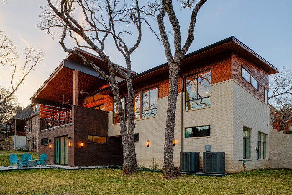 Cette image montre une façade de maison multicolore minimaliste en brique de taille moyenne et à niveaux décalés avec un toit en appentis et un toit en métal.