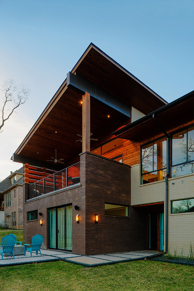 Ejemplo de fachada de casa multicolor minimalista de tamaño medio a niveles con revestimiento de ladrillo, tejado de un solo tendido y tejado de metal