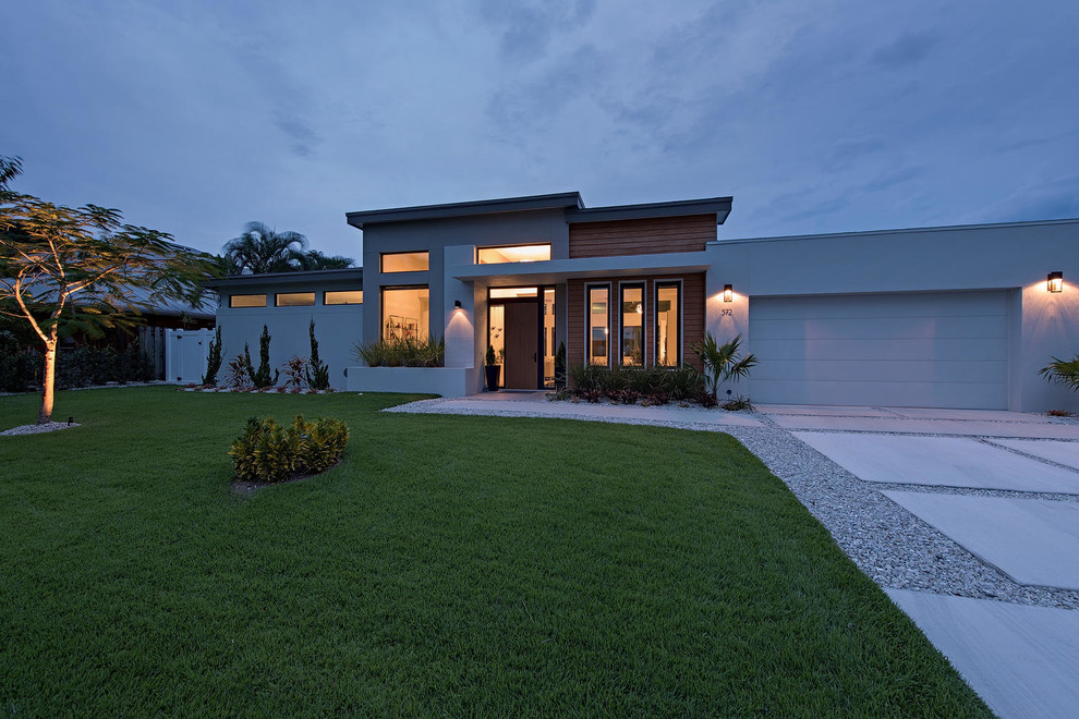 Mittelgroßes, Einstöckiges Modernes Haus mit Putzfassade, grauer Fassadenfarbe und Flachdach in Miami