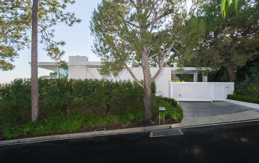 Immagine della villa bianca contemporanea a un piano con rivestimento in stucco e tetto piano