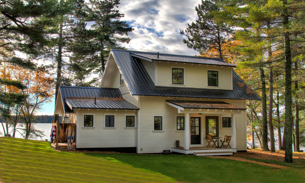 Ispirazione per la villa beige rustica a due piani con tetto a capanna e copertura in metallo o lamiera
