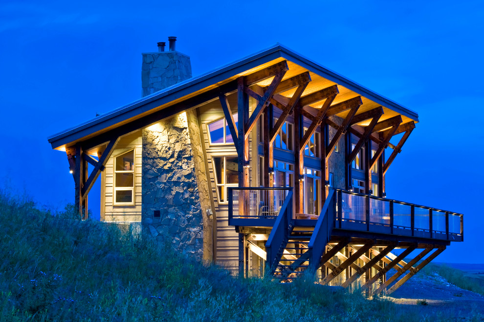 Inspiration for a rustic two floor house exterior in Calgary with a lean-to roof.