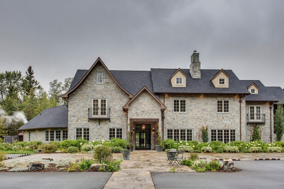 Diseño de fachada de casa multicolor de estilo de casa de campo grande de tres plantas con revestimiento de piedra, tejado a dos aguas y tejado de teja de madera