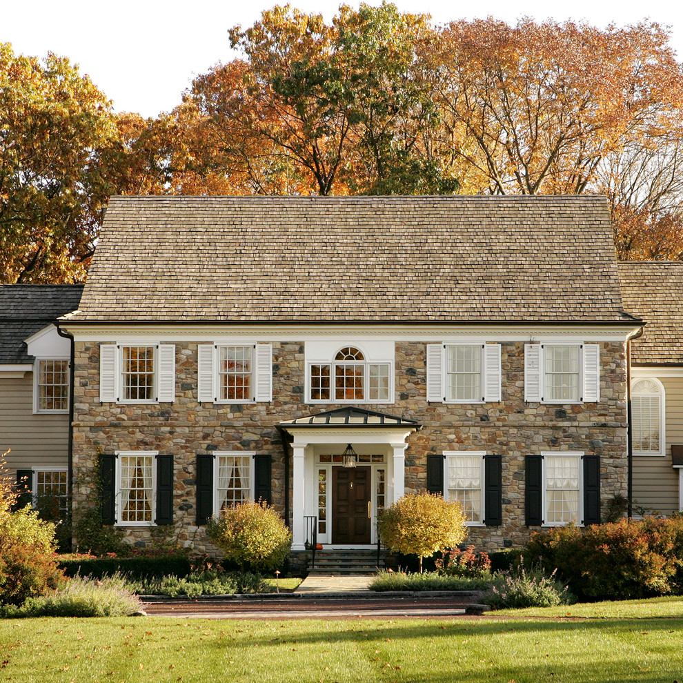 Aménagement d'une façade de maison classique en pierre à deux étages et plus avec un toit à deux pans.