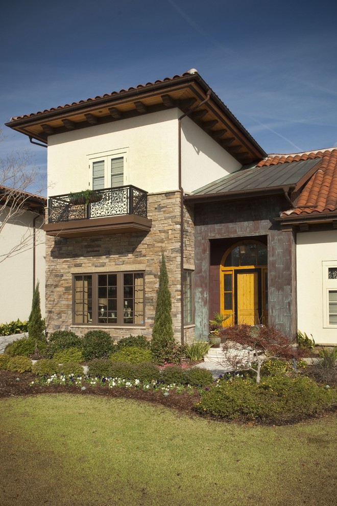 Example of a tuscan metal exterior home design in Other with a mixed material roof