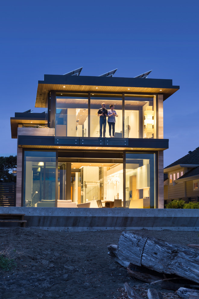 Aménagement d'une petite façade de maison grise contemporaine en pierre à un étage avec un toit plat.