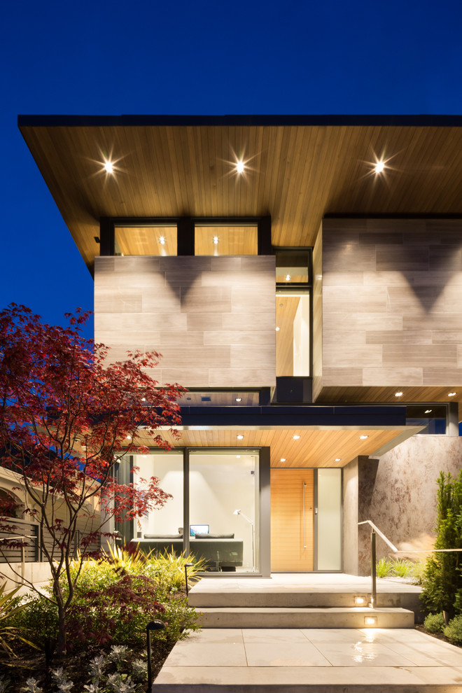 Стильный дизайн: маленький, двухэтажный, серый дом в современном стиле с облицовкой из камня и плоской крышей для на участке и в саду - последний тренд