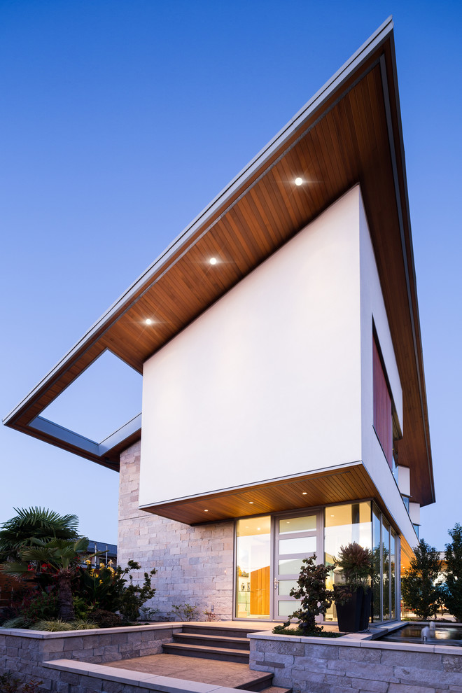 Cette image montre une façade de maison grise design de taille moyenne et à un étage avec un revêtement mixte.