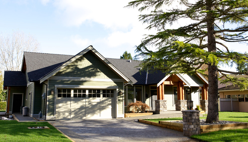 Photo of a medium sized and green traditional bungalow house exterior in Vancouver with concrete fibreboard cladding and a half-hip roof.