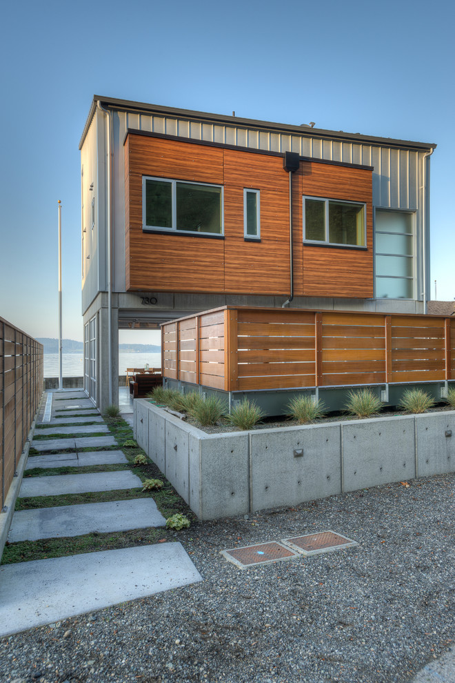 Photo of a small and gey contemporary two floor detached house in Seattle with metal cladding, a lean-to roof and a metal roof.