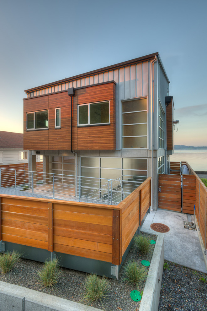 Mittelgroßes, Zweistöckiges Modernes Einfamilienhaus mit Metallfassade, grauer Fassadenfarbe, Pultdach und Blechdach in Seattle
