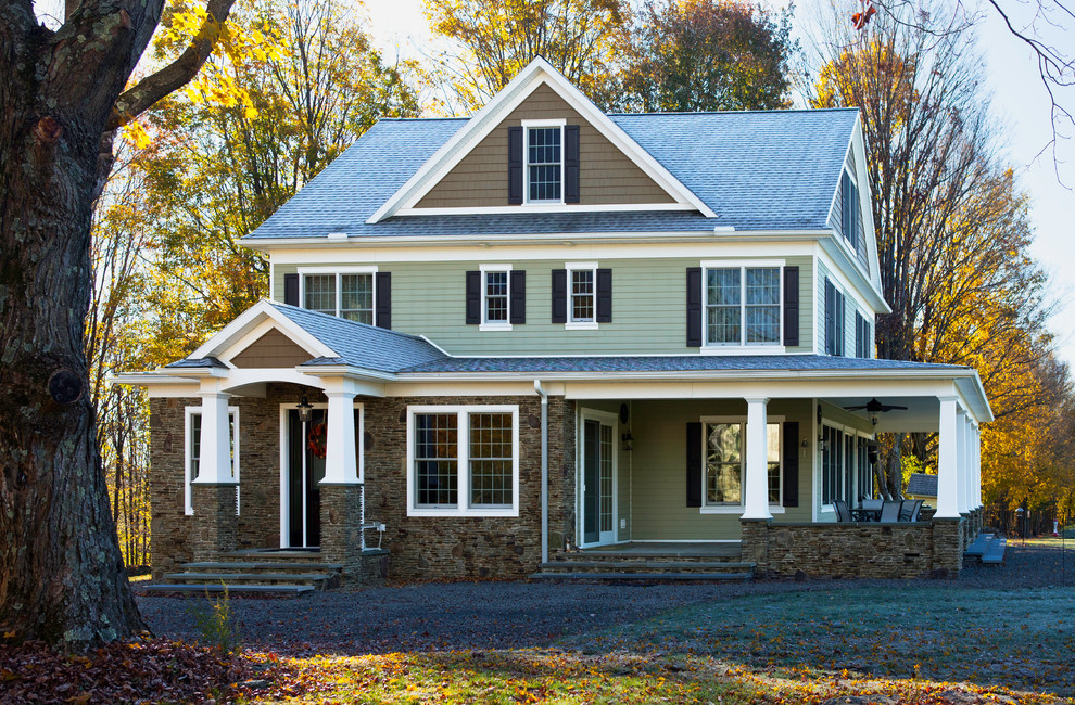 Réalisation d'une façade de maison verte chalet de taille moyenne et à deux étages et plus avec un revêtement mixte et un toit à deux pans.