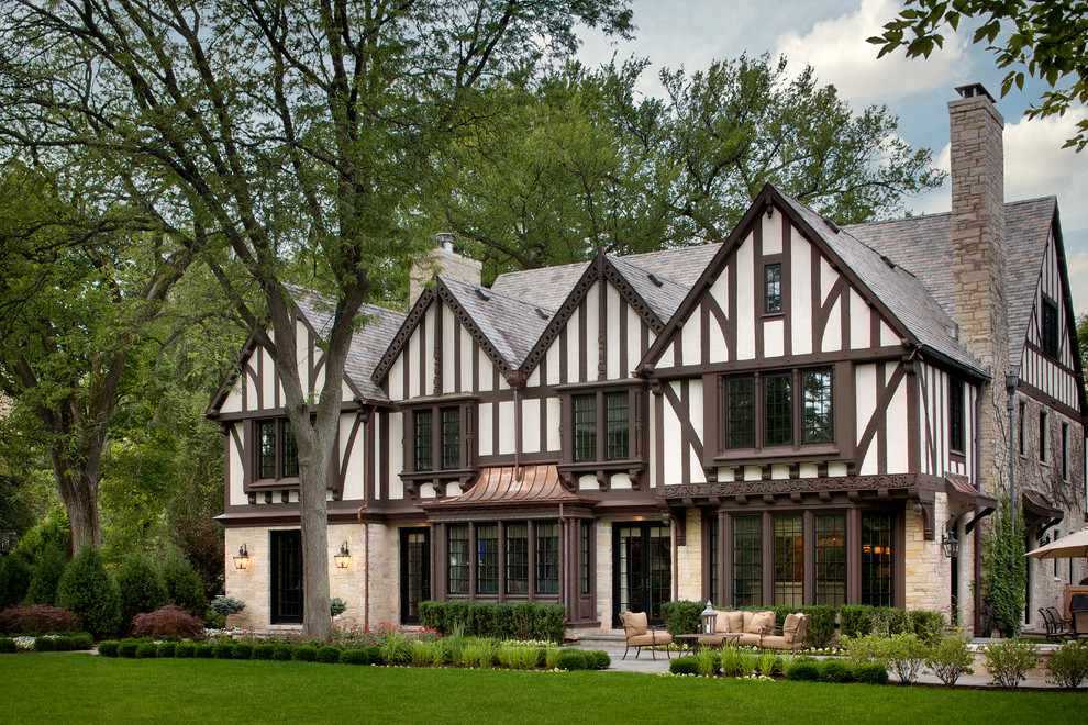 Idee per la facciata di una casa ampia beige classica a tre piani con rivestimento in stucco e tetto a capanna