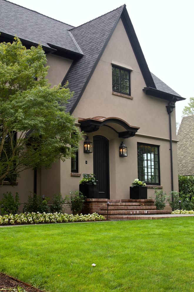 Inspiration for a large timeless beige two-story stucco gable roof remodel in Portland
