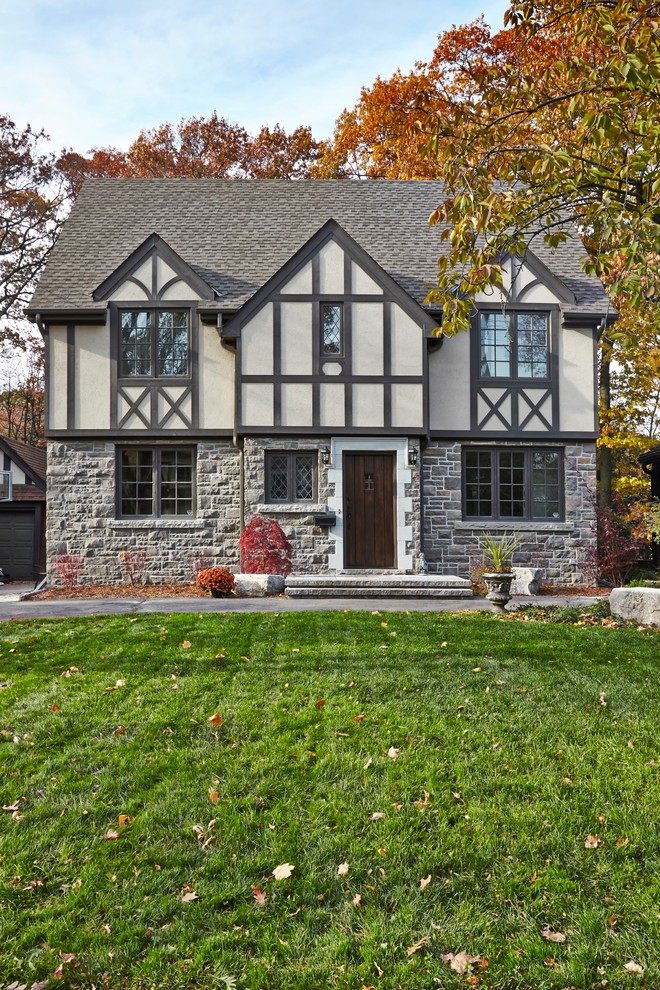 Пример оригинального дизайна: двухэтажный, большой, серый дом в классическом стиле с облицовкой из камня