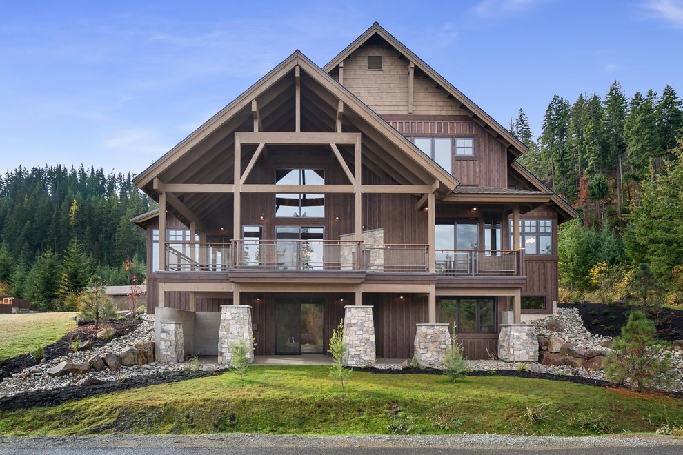 Cette photo montre une façade de maison marron montagne en bois à deux étages et plus avec un toit à deux pans.