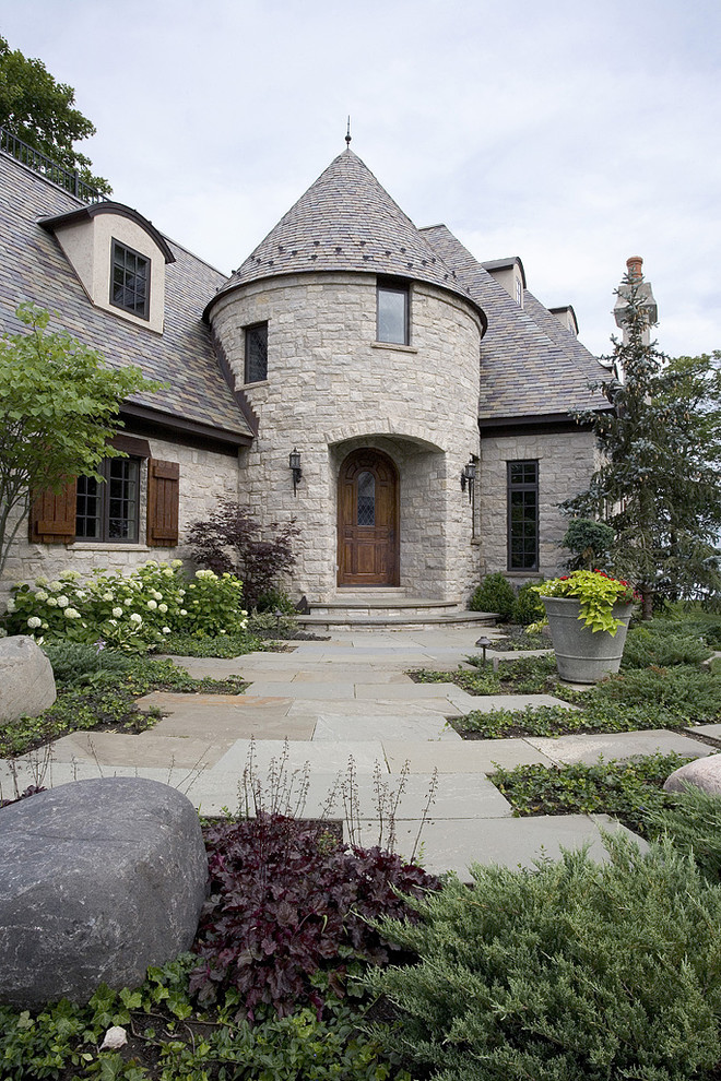 Inspiration for an expansive and beige traditional house exterior in Chicago with stone cladding, three floors and a hip roof.