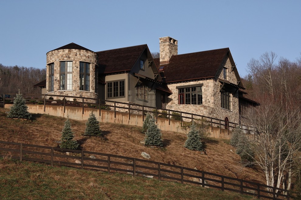 Exemple d'une grande façade de maison marron montagne en pierre à un étage.