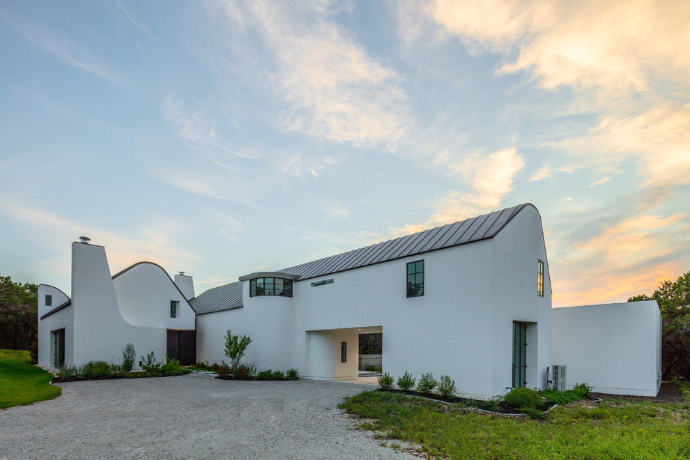Ejemplo de fachada de casa blanca contemporánea grande de dos plantas con revestimiento de estuco, tejado a doble faldón y tejado de metal