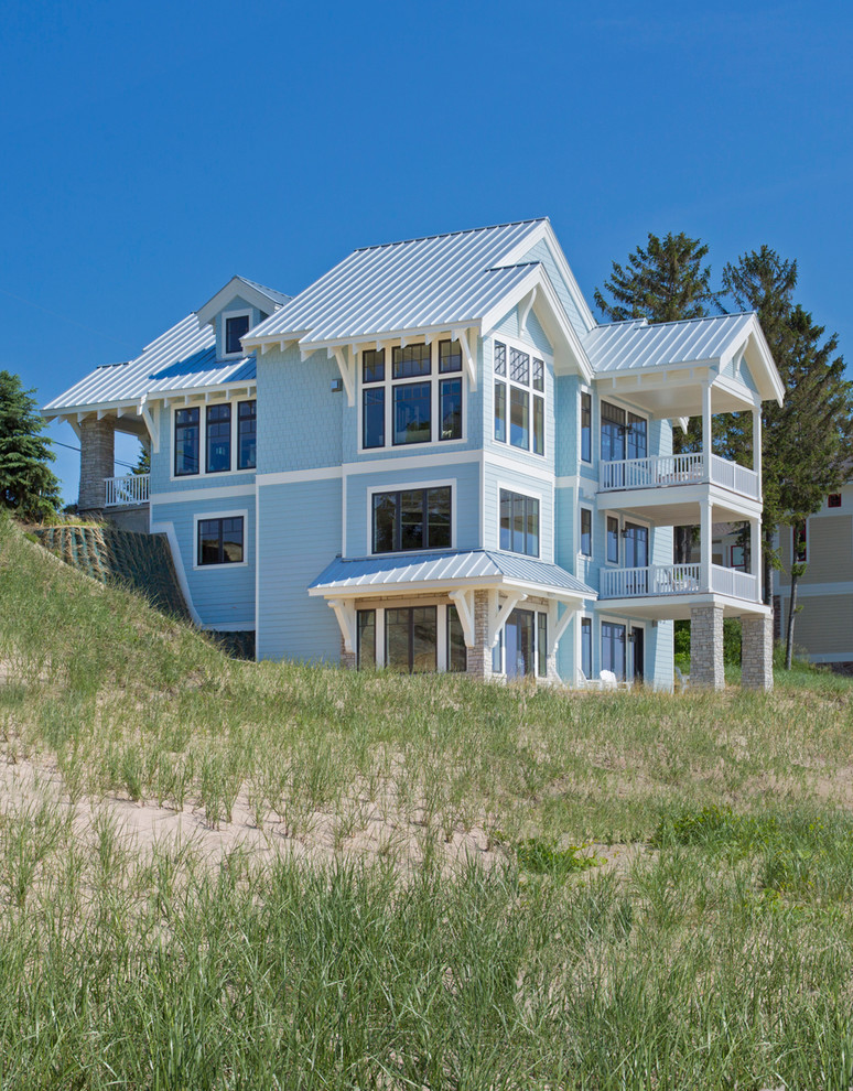 Example of a large beach style blue three-story concrete fiberboard exterior home design in Grand Rapids