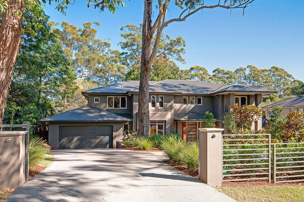 Large trendy gray two-story stucco exterior home photo in Sydney with a hip roof