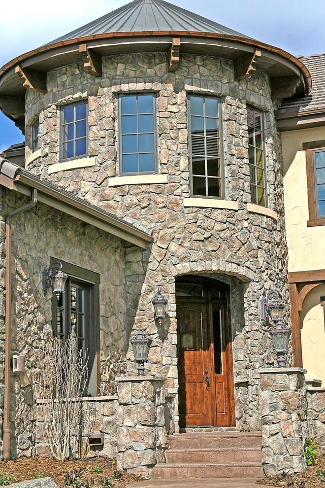 Large mediterranean two-story stone exterior home idea in Denver