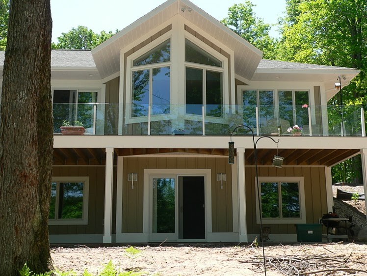 Esempio della facciata di una casa beige american style a due piani di medie dimensioni con tetto a padiglione e rivestimento con lastre in cemento