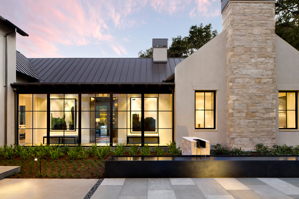Ejemplo de fachada de casa beige minimalista grande de una planta con tejado de metal