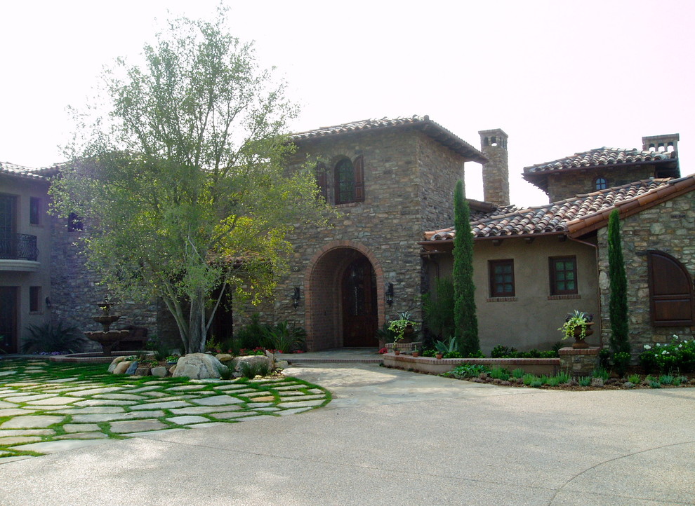 Example of a large tuscan beige two-story stucco house exterior design in San Diego with a shingle roof