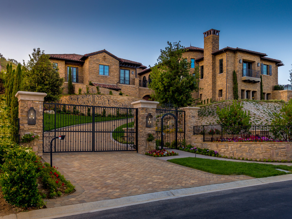 Zweistöckiges Mediterranes Einfamilienhaus mit Steinfassade, brauner Fassadenfarbe, Walmdach, Ziegeldach und rotem Dach in Los Angeles