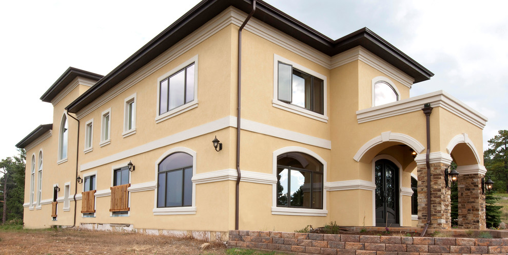 This is an example of a beige retro two floor render house exterior in Denver.