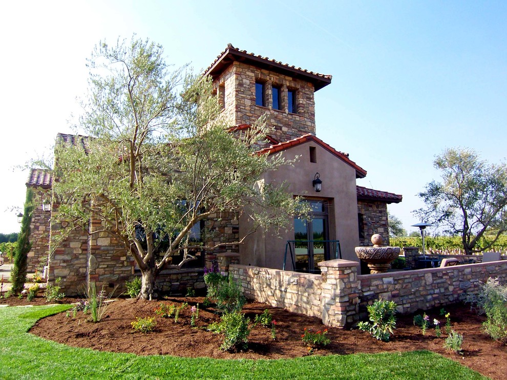 Large mediterranean beige two-story stone exterior home idea in Other