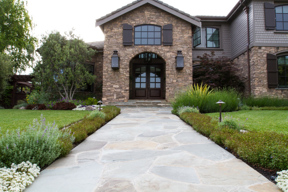 Large mediterranean beige two-story stone exterior home idea in San Francisco with a clipped gable roof