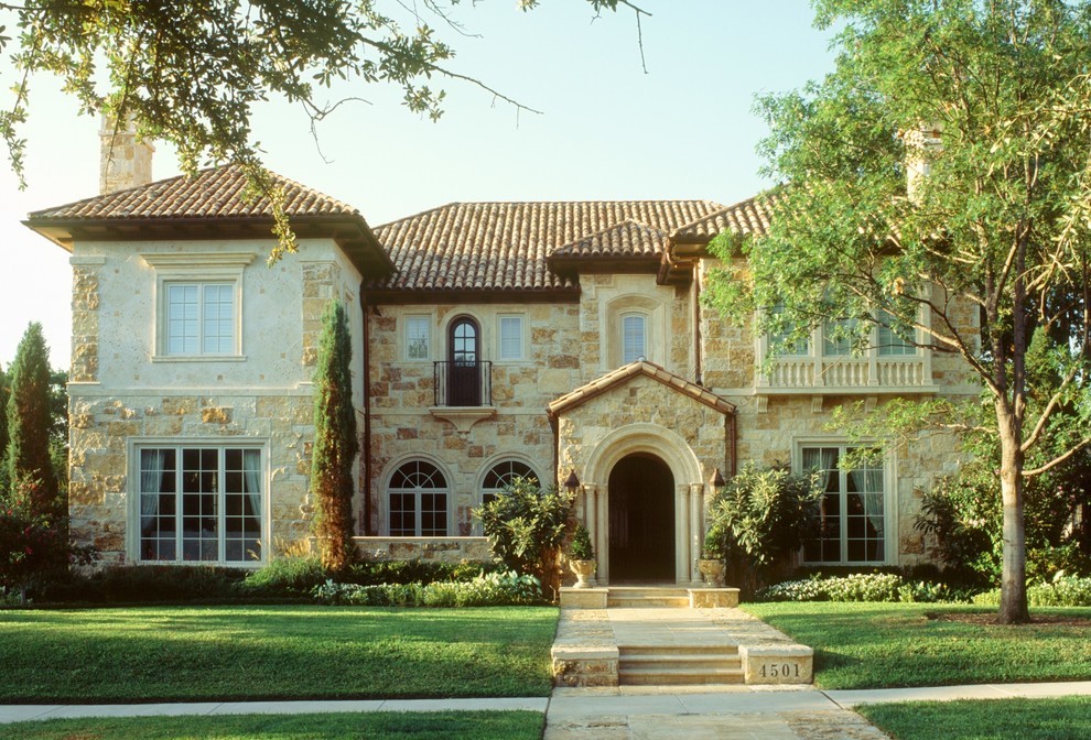 Large tuscan beige two-story stone exterior home photo in Dallas