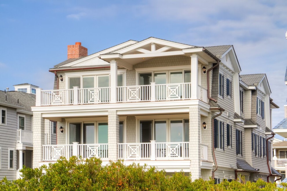 Aménagement d'une façade de maison beige bord de mer en bois de taille moyenne et à deux étages et plus.