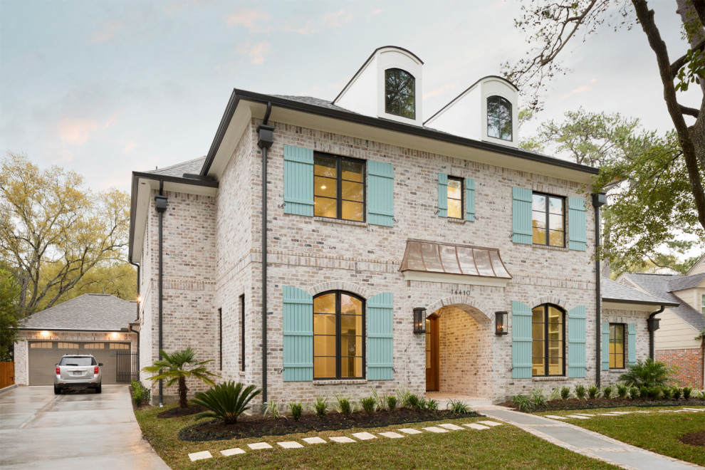 Mittelgroßes, Zweistöckiges Klassisches Einfamilienhaus mit Schindeldach, Backsteinfassade, beiger Fassadenfarbe und Walmdach in Houston
