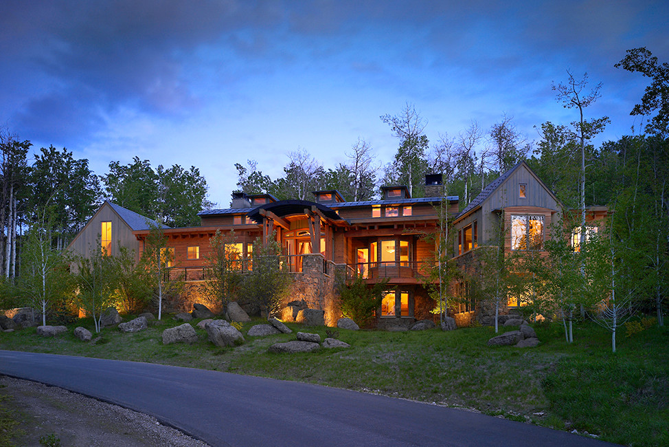 Cette photo montre une grande façade de maison multicolore montagne en bois à deux étages et plus avec un toit en métal.