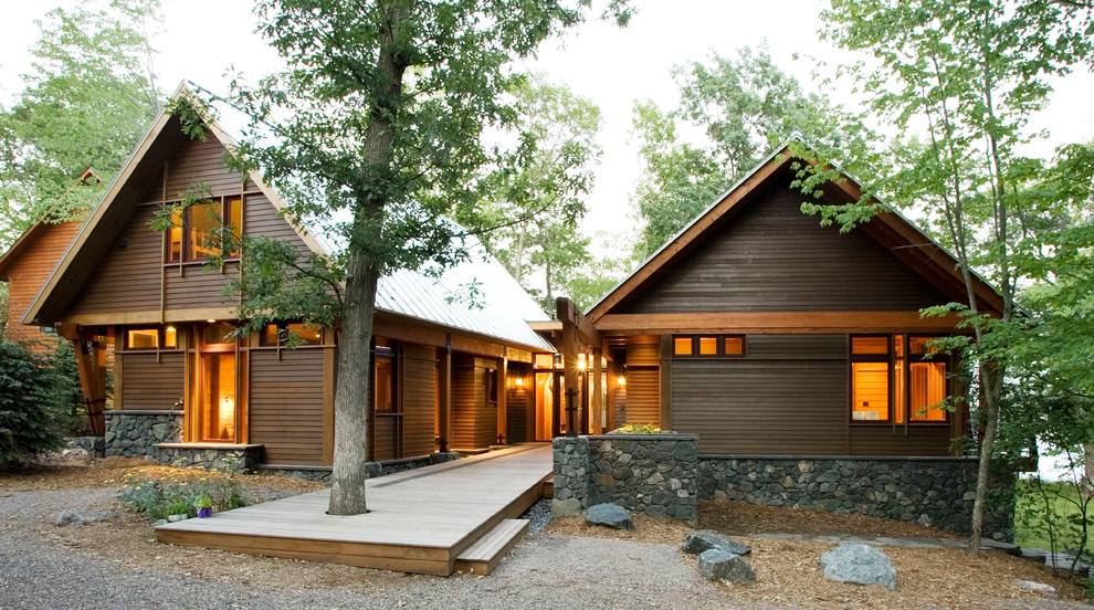 This is an example of a large and brown rustic two floor house exterior in Minneapolis with wood cladding.
